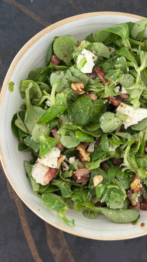 Ensalada de canónigos, nueces tostadas, bacon y queso fresco de cabra