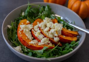 Ensalada con rúcula, calabaza asada, queso y bocados de heura a la plancha