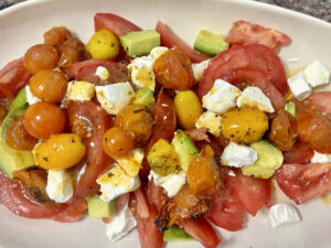 Ensalada de tomate, queso fresco de cabra, aguacate y tomates cherry horneados