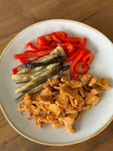 Pavo rehogado con pimentón, pimiento y berenjena asados