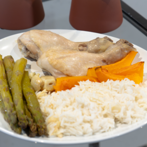 Muslos de pollo al horno con calabaza y espárragos asados acompañados de arroz