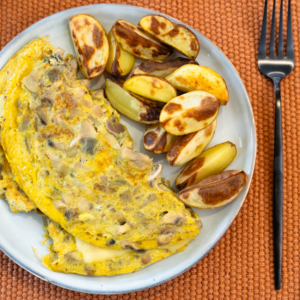 Tortilla francesa de champiñones y queso con patatas horneadas