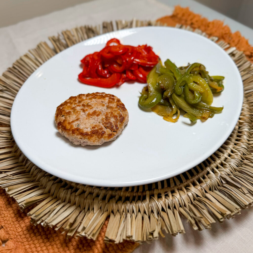 Hamburguesa de cerdo con pimientos rehogados y patatas asadas