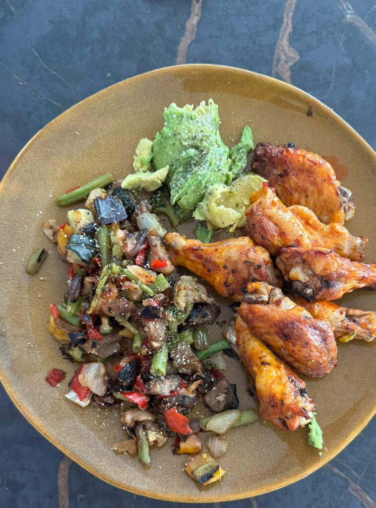 Alitas de pollo con vegetales rehogados y aguacate