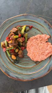 Hamburguesa de pollo con vegetales rehogados